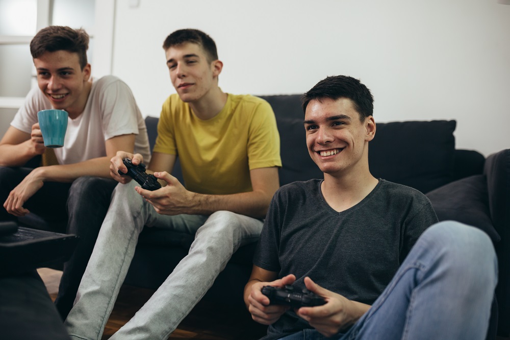 Teenage boys playing a games console together