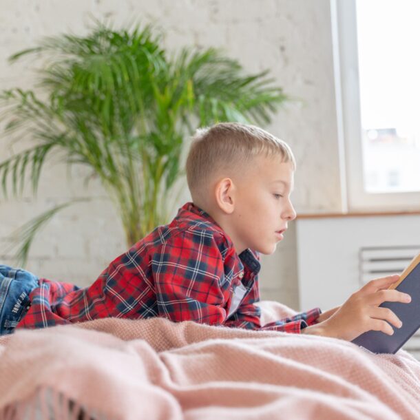 Boy reading religious book on his bed