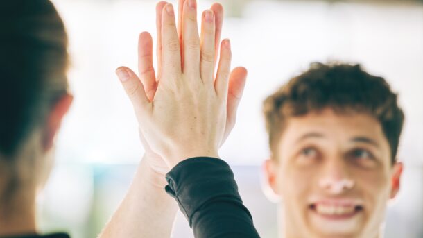 Male and female high fiving each other