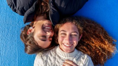 Two girls laughing with each other