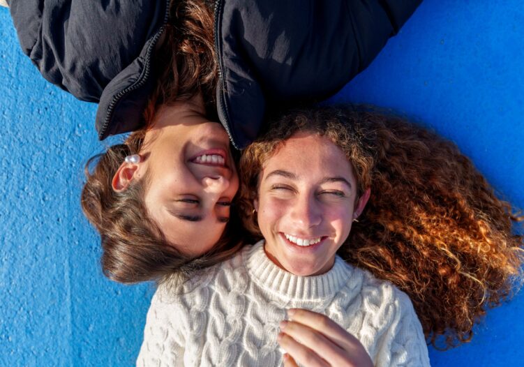 Two girls laughing with each other